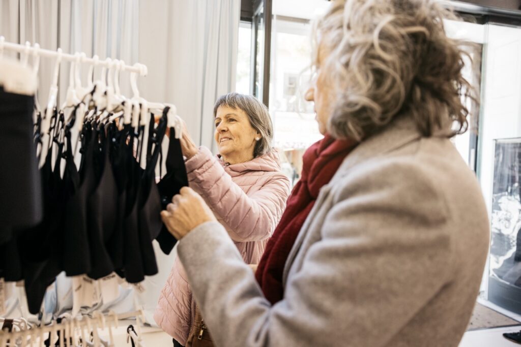 oudere vrouw kiest onderkledij in winkelrek bij diva gespecialiseerd in onderkledij voor ouderen advies en comfort