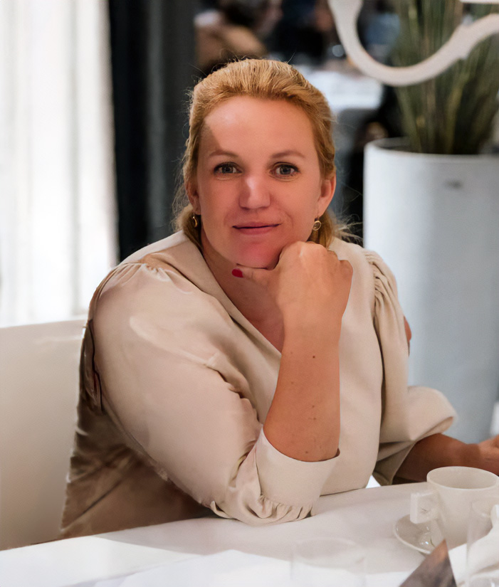 vrouw met beige blouse zittend aan tafel ontspannen en denkend diva onderkledij ouderen pagina